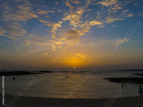 People going for a swim at sunset at a Atlantic lagoon at summer