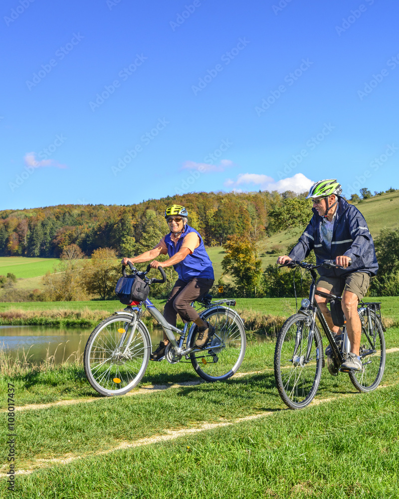 Senioren-Paar macht gutgelaunt eine Radtour