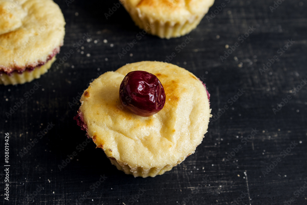Curd cupcakes with cherries on a black background. Food photo. Curd cupcakes with cherries on a black background. Food photo.