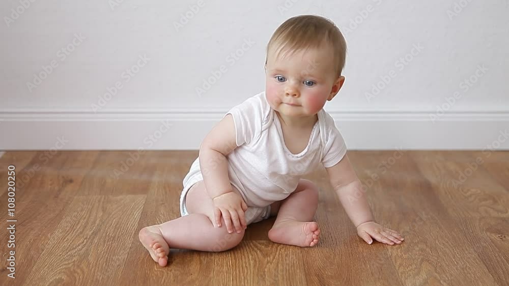 little baby sitting on wooden floor little baby sitting on wooden floor