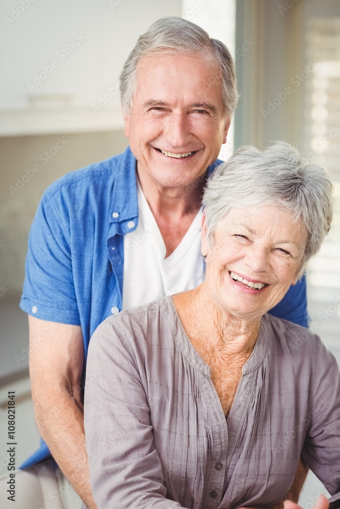 Portrait of happy senior man embracing wife
