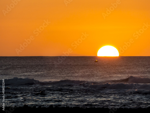 Sunset at the Atlantic Ocean with a big sun sinking in the sea. © sotavento1000