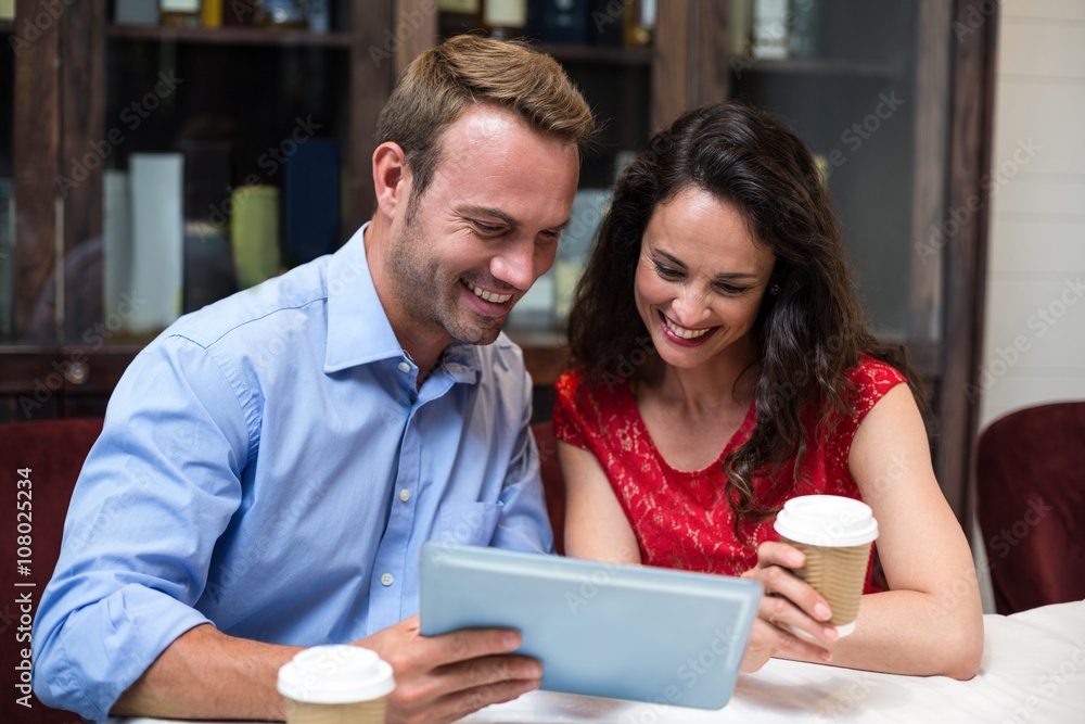 Happy couple using digital tablet while having coffee Happy couple using digital tablet while having coffee
