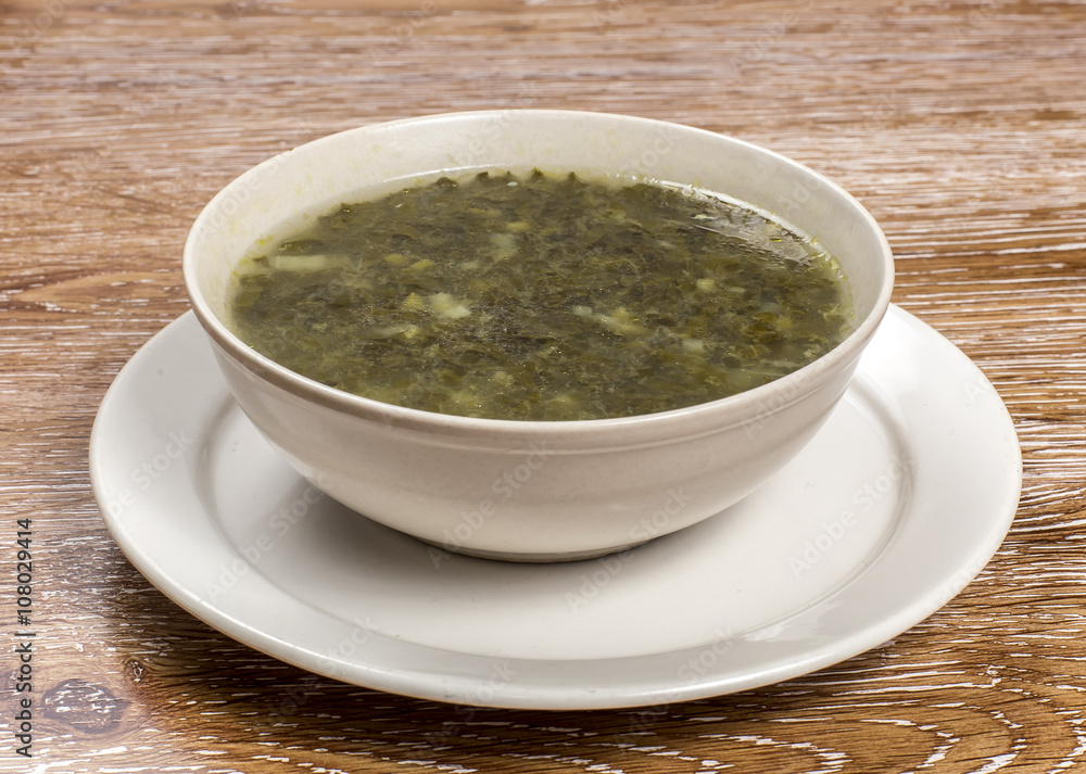 Traditional green dietary soup in a bowl on wooden background Traditional green dietary soup in a bowl on wooden background