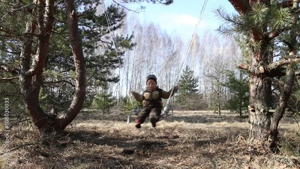 Gomel, Belarus - April 3, 2016: Family in a forest glade ride on a swing. Gomel, Belarus - April 3, 2016: Family in a forest glade ride on a swing.