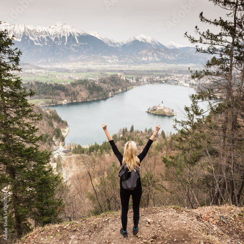 Made it. Young spoty active lady with hands rised admiring beautiful nature around Bled Lake in Julian Alps, Slovenia. photo