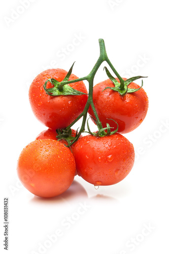 ripe tomatoes in drops of water close-up on a white background