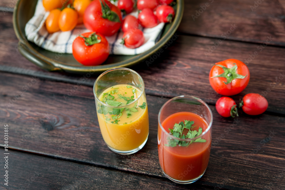 Glass of tomato juice with vegetables on old wooden background, with greenery and tomatoes Glass of tomato juice with vegetables on old wooden background, with greenery and tomatoes