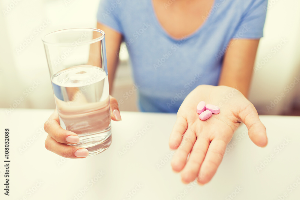 close up of woman hands with pills and water close up of woman hands with pills and water