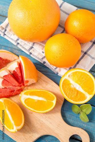 close up of fresh delicious oranges and grapefruit on an old wooden background