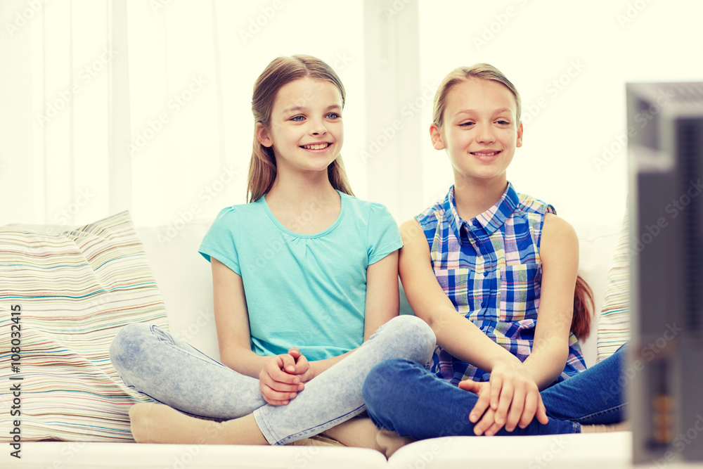 Obraz premium two happy little girls watching tv at home