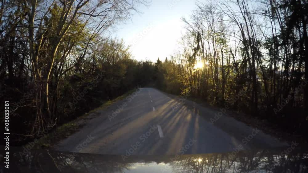 Driving car on sunset in flares