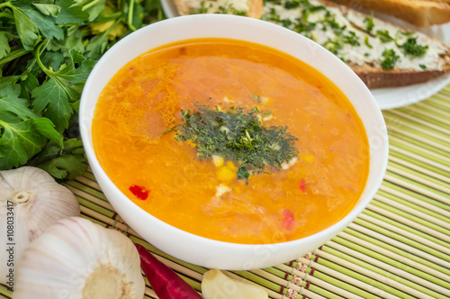 Traditional oriental soup with tomatoes, red lentils, green