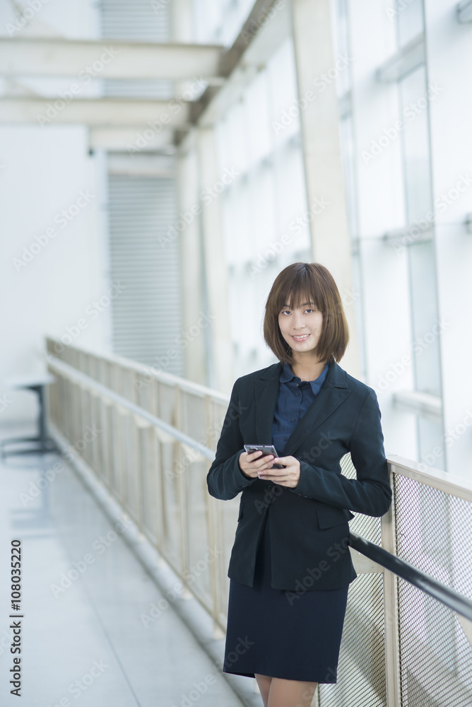 Attractive asian business woman using on smartphone outside Offi