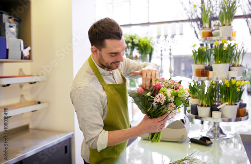 smiling florist man making bunch at flower shop