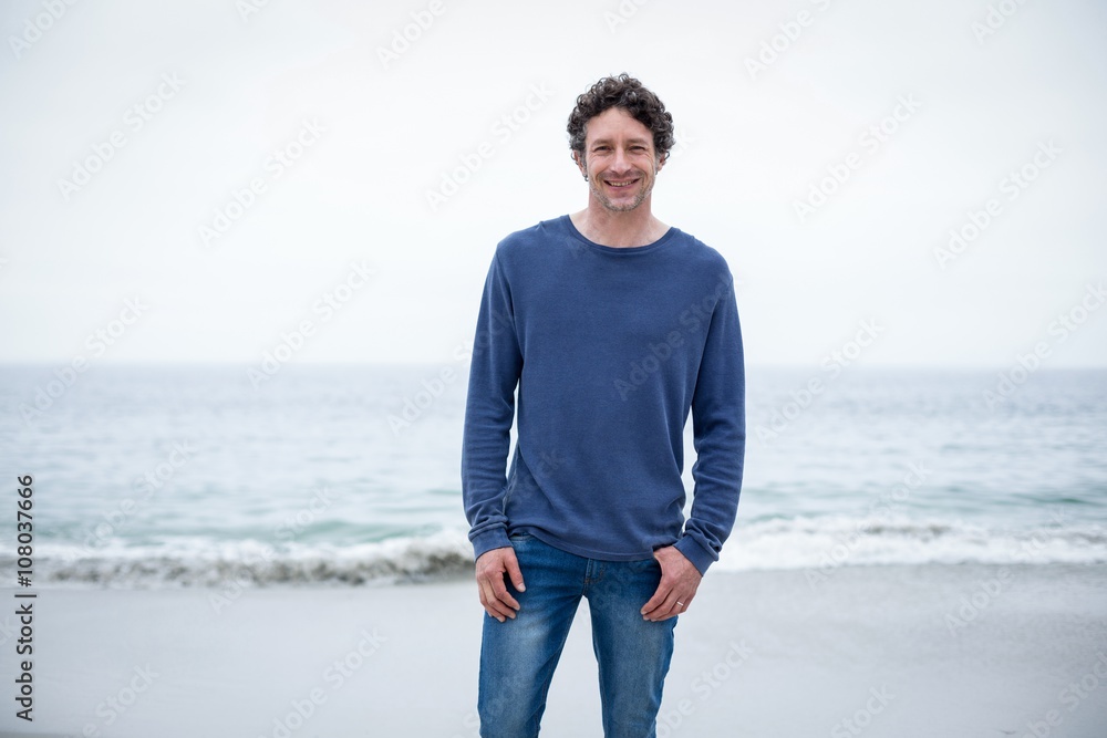 Confident man smiling while standing at sea shore Confident man smiling while standing at sea shore