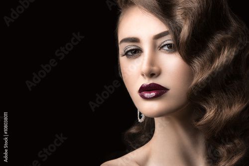 Beautiful brunette in  Hollywood manner with curls  dark lips. Beauty face. 