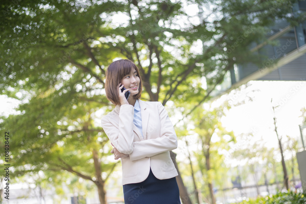 Attractive asian business woman using on smartphone outside Offi Attractive asian business woman using on smartphone outside Offi