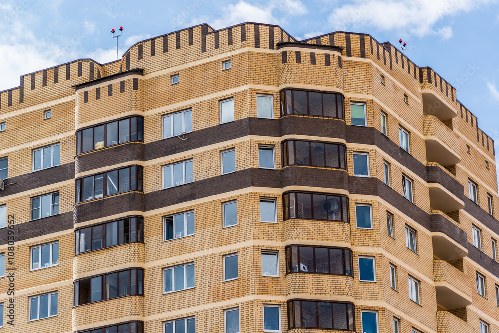 Modern high-rise apartment building made of brick Modern high-rise apartment building made of brick