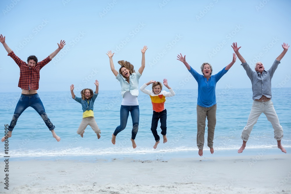 Multi-generation family jumping at sea shore
