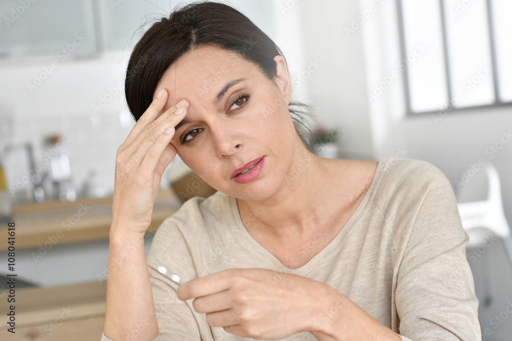 Fototapeta premium Woman having headache, taking pills
