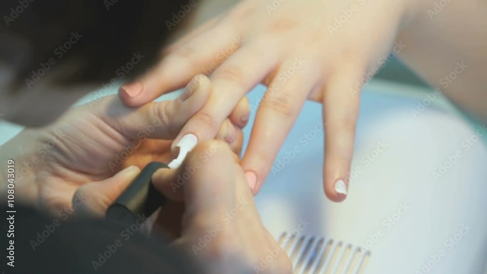 Woman making the manicure girl at the beauty salon Woman making the manicure girl at the beauty salon
