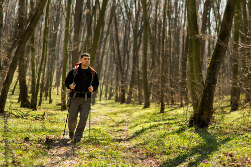 Male hiker looking to the side walking in forest