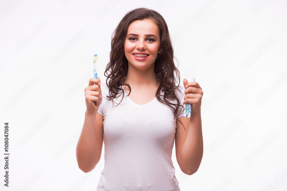 Portrait of a beautiful woman with braces on the teeth, cleans teeth with toothbrush, isolated on a white background Portrait of a beautiful woman with braces on the teeth, cleans teeth with toothbrush, isolated on a white background