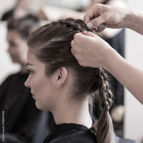 Braiding young woman's hair