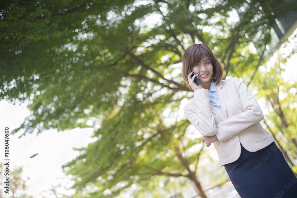 Attractive asian business woman using on smartphone outside Offi Attractive asian business woman using on smartphone outside Offi