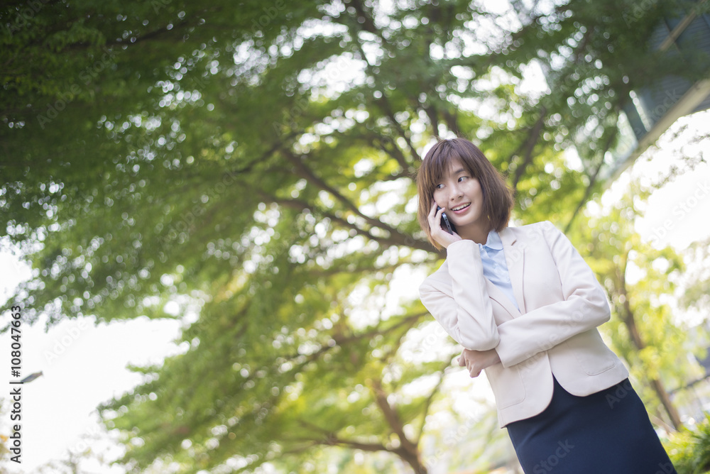 Attractive asian business woman using on smartphone outside Offi Attractive asian business woman using on smartphone outside Offi