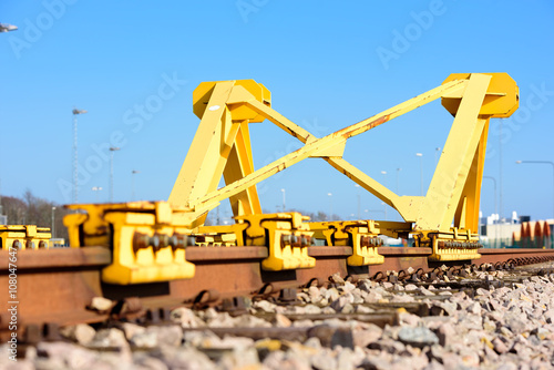 Bright yellow train buffer stop or bumper at the end of a railway track.