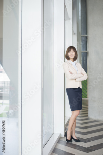 Attractive asian business woman smiling outside office