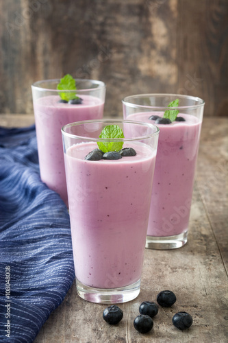 Blueberry smoothie in a glass on a rustic table 