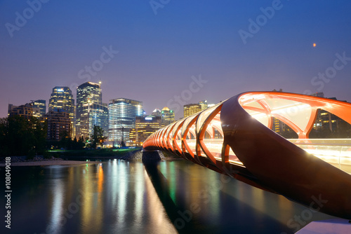 Calgary cityscape with Peace Bridge and downtown skyscrapers in Alberta at night, Canada.