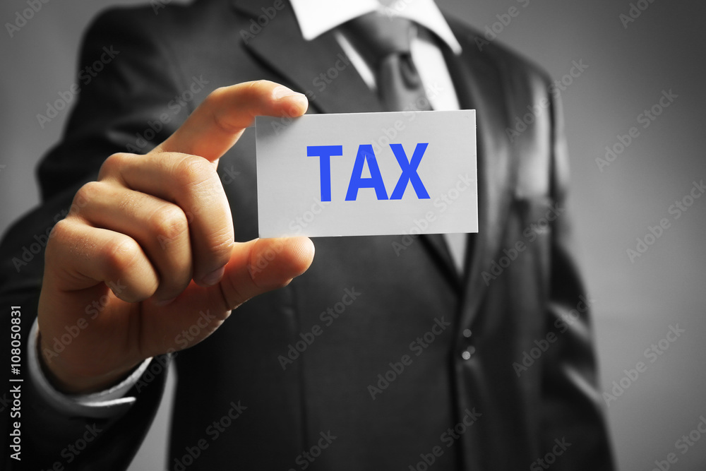 Tax Concept. Handsome businessman holding business card close up Tax Concept. Handsome businessman holding business card close up