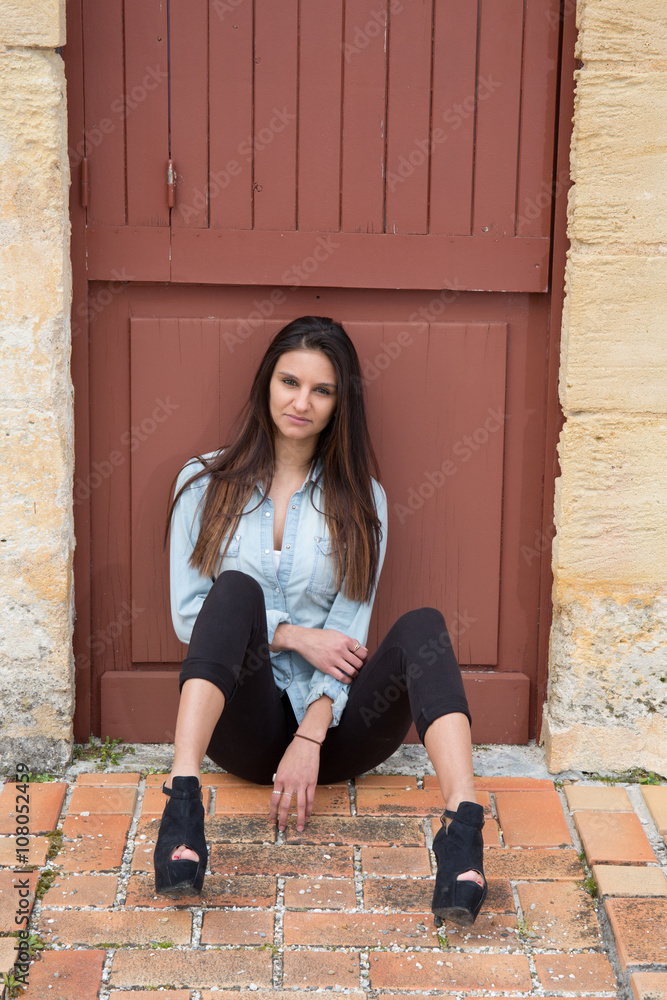 Dressing in a blue blazer, black pants and high heels shoes, a brunette  teenage girl is sitting outside Stock Photo | Adobe Stock