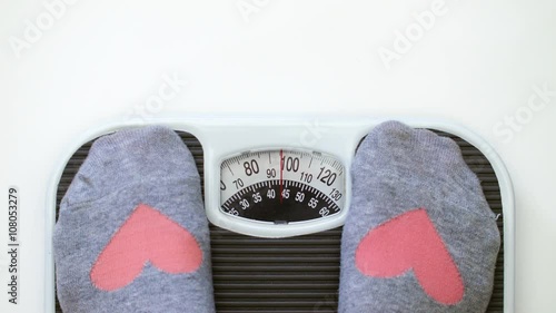 Room for Text and 95lbs - 43kg Woman Stepping on Bathroom Scale to measure here Weight.