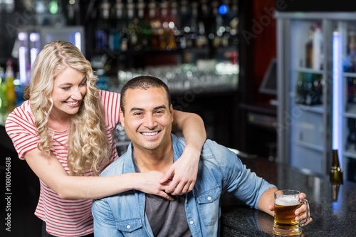 Smiling couple having a drink in a bar