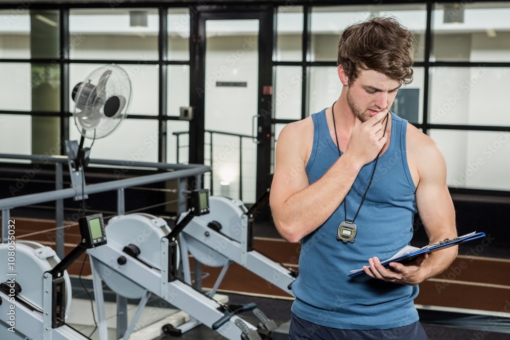 Fototapeta premium Gym trainer looking at the clipboard