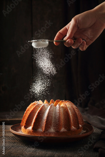 Fotografi Sprinkling of orange cake with powdered sugar
