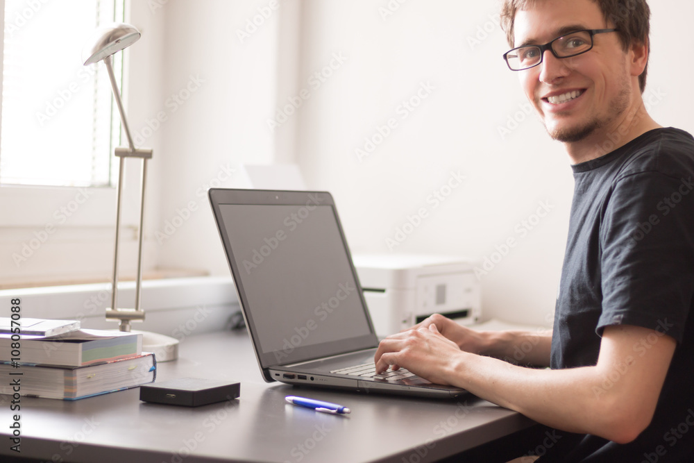 Junger Mann arbeitet an Laptop Junger Mann arbeitet an Laptop