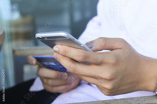 close up businessman playing smart phone and try to make payment online by credit card