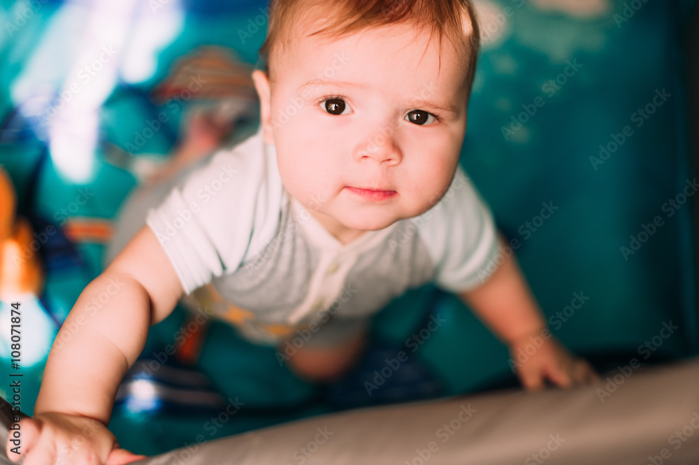 Cute little baby boy playing in colorful playpen, indoors. Beautiful child having fun at nursery. Cute little baby boy playing in colorful playpen, indoors. Beautiful child having fun at nursery.