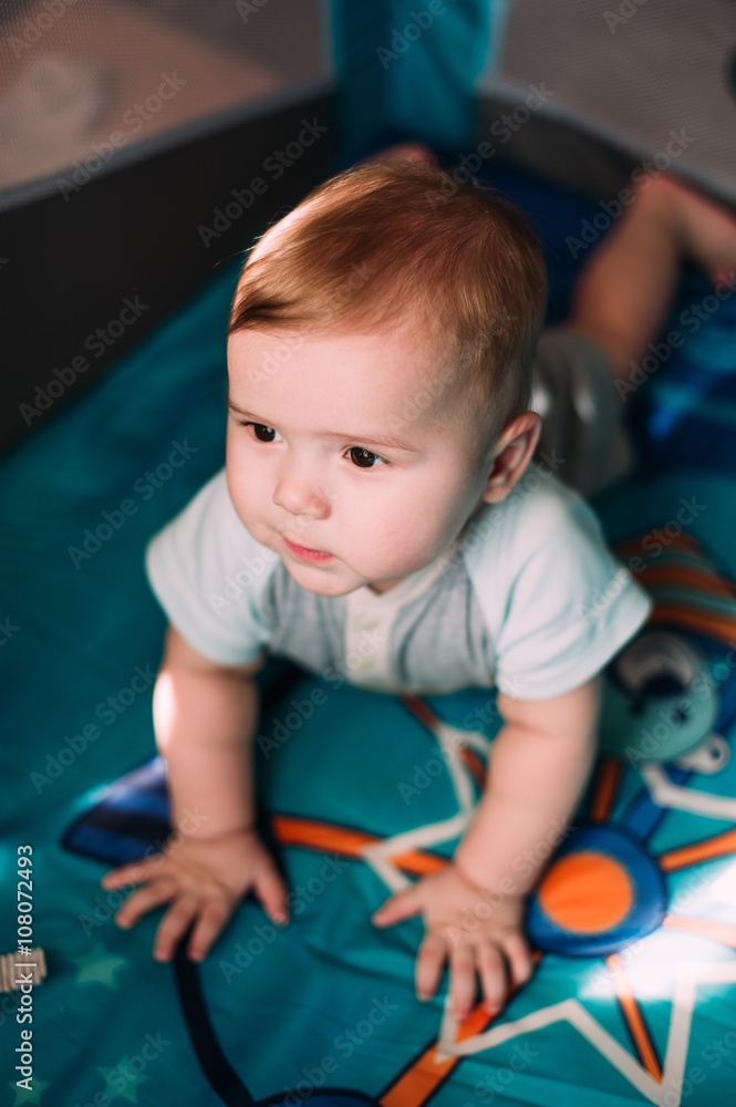 Cute little baby boy playing in colorful playpen, indoors. Beautiful child having fun at nursery. Cute little baby boy playing in colorful playpen, indoors. Beautiful child having fun at nursery.