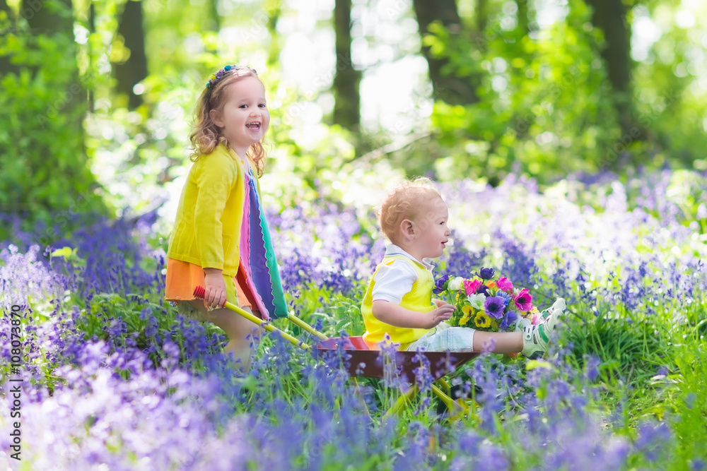 Kids in a garden with bluebell flowers Kids in a garden with bluebell flowers
