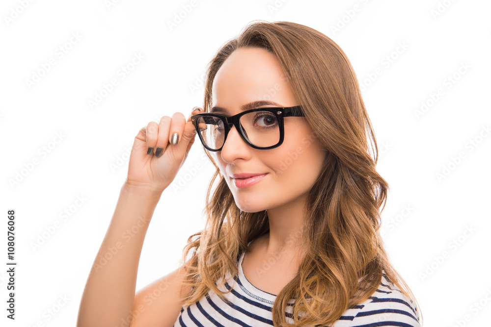 Portrait  of attractive brainy young woman touching her glasses