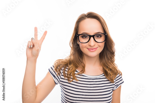 Portrait of smiling young woman gesturing with two fingers