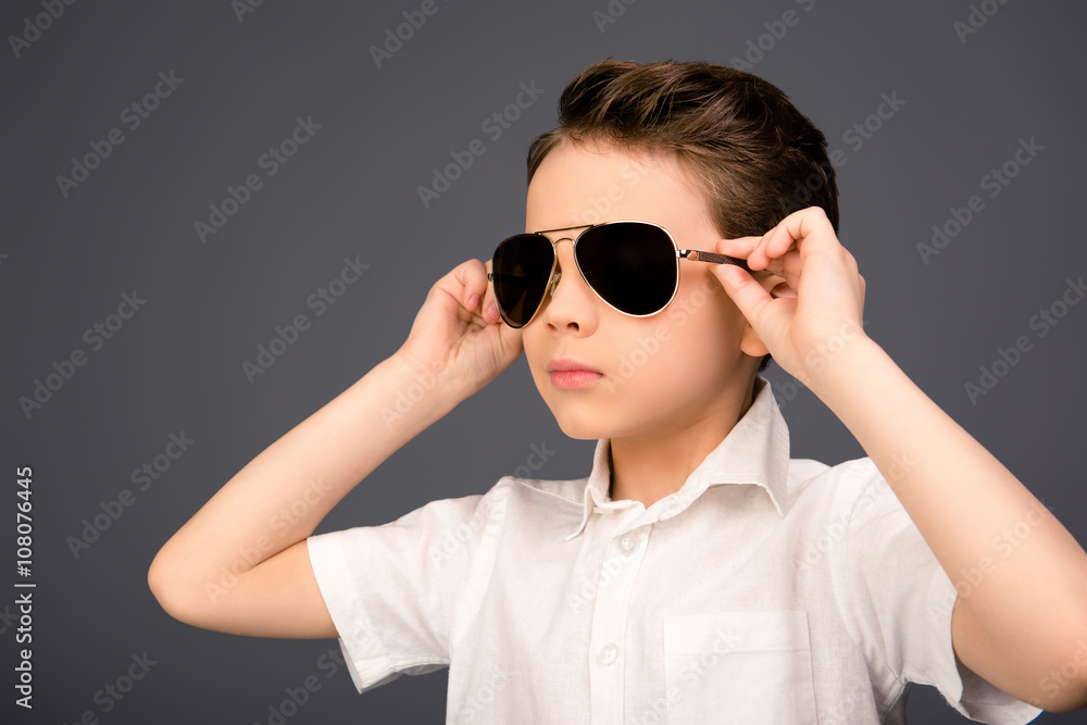 Portrait of serious cool kid touching his spectacles Portrait of serious cool kid touching his spectacles