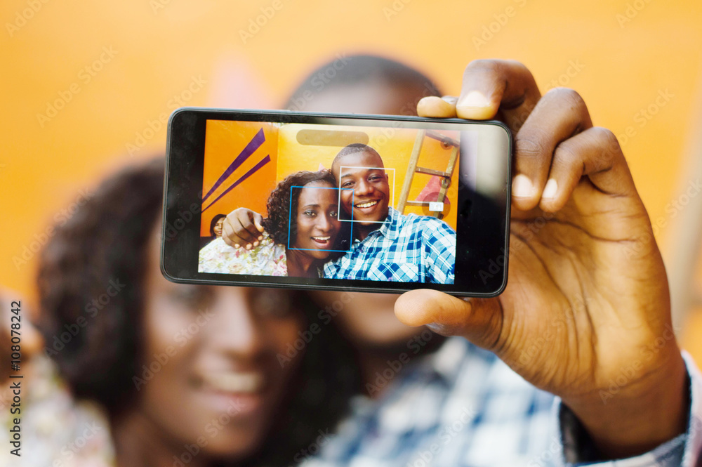 young couple taking pictures  with their mobile phone.